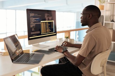 Ofisteki bilgisayarda çalışan ciddi bir programcı.