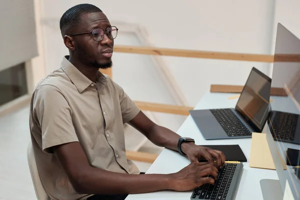 Serious Black programmer developing software updates side view