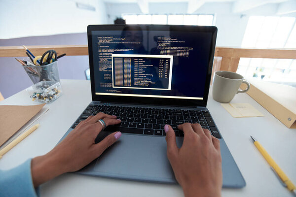 Hands of programmer testing code of new software on laptop