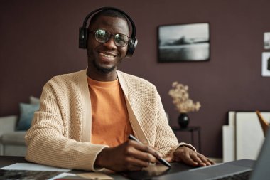 Proje için yeni tasarım sistemi üzerinde çalışırken müzik dinleyen neşeli grafik tasarımcı portresi