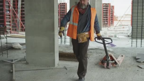Langsam Schleppt Ein Älterer Kaukasischer Bauarbeiter Bollenhut Und Sicherheitsweste Einen — Stockvideo