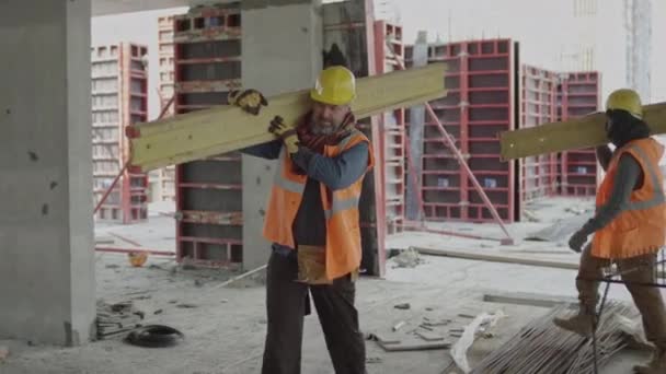 완성되지 콘크리트 미래의 부동산을 어깨에 무거운 판자를 민족적으로 동료의 슬로우 — 비디오