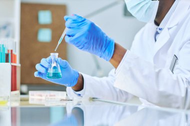 Laboratuvar teknisyenlerinin tıbbî araştırma yaparken pipetle sıvı örnekleri almalarını kapatın.