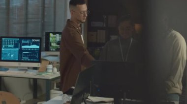 Modern ofiste masaüstü bilgisayarının başında duran ve tartışan çok ırklı programcıların birlikte çalıştığı yeni yazılımlar.