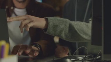 Genç beyaz kadın mühendisin bilgisayar ekranını gösterirken, melez erkek meslektaşına yeni yazılım geliştirme konusunda yardım ederken çekimini yukarı kaldır.