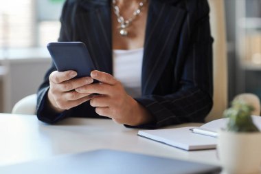 Ofisteki iş yerinde akıllı telefon kullanan kadın yöneticinin kapatılması, boşluğun kopyalanması