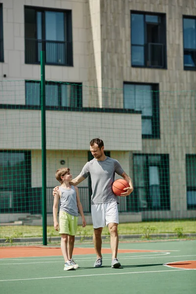 Baba Oğlunun Birlikte Basketbol Oynadığı Güneş Işığında Sahada Durduğu Dikey — Stok fotoğraf