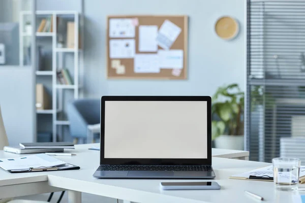 Background image of open laptop on desk with white screen mock up, copy space