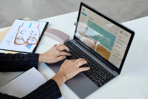 stock image Close up of unrecognizable senior woman typing at laptop keyboard while working in office, copy space