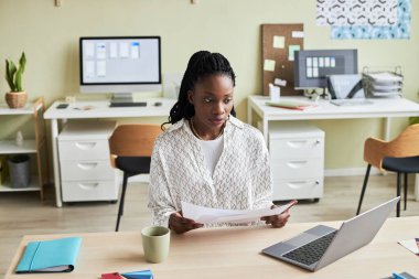 Rahat ofis ortamında çalışırken dizüstü bilgisayar kullanan siyahi genç bir kadının portresi, boşluğu kopyala