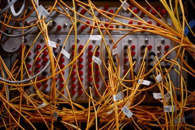 Bağlantı noktalarına bağlı sarı internet kablosu ve kabloları olan sunucu kabininin arkaplan resmini kapat, boşluğu kopyala