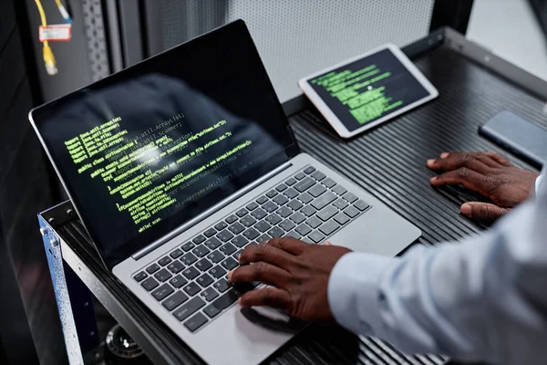 Stock image High angle close up of network engineer or hacker using laptop with green code lines in server room, copy space