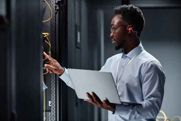 Veri Merkezinde Sunucularla Çalışan Dizüstü Bilgisayar Tutan Genç Siyahi Bir — Stok fotoğraf