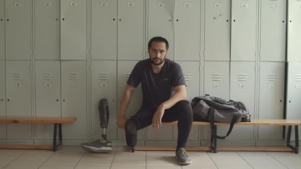 Soyunma Odasında Bankta Oturan Kameraya Bakan Uzuv Protezi Takılı Genç — Stok video