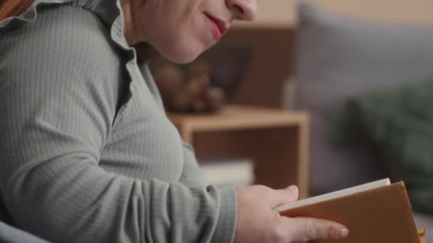 白种人年轻女子在闲暇时间在家看纸质书的倾斜 — 图库视频影像