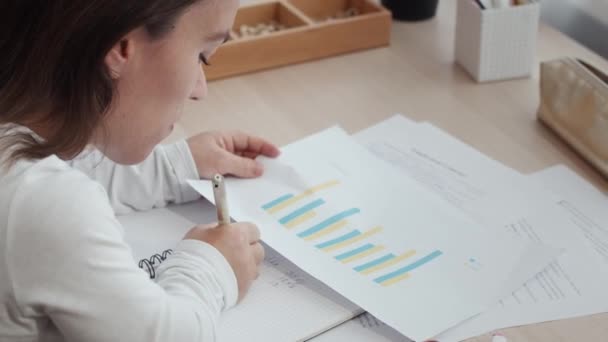 Vue Dessus Jeune Femme Caucasienne Prenant Des Notes Analysant Graphique — Video