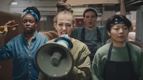 若い支持的な多民族女性のチーム マウスピースとフェミニストのボール紙バナー 工業工場に沿って歩いて 彼らの抗議を決定的に示す — ストック動画