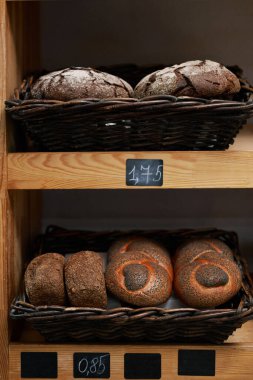 Çavdar ekmekli sepetler, glütensiz somunlar ve raflarda haşhaş tohumlu ekmek.