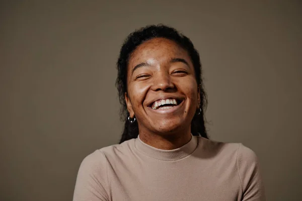 スタジオで中立的なベージュの背景に笑う黒人の若い女性の候補者の肖像画 肌の質に焦点を当てます — ストック写真