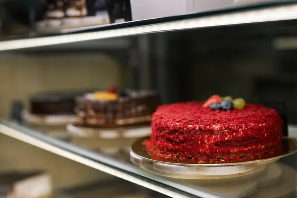 Sweet cakes decorated with berries in bakery showcase