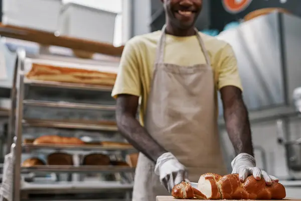 Улыбающийся Пекарь Нарезает Плетеный Хлеб Маком Клиента — стоковое фото