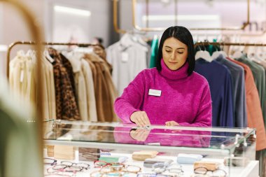 Lüks butikte cam silen genç bir kadının belden yukarı portresi açılışa hazırlanırken, boşluğu kopyala