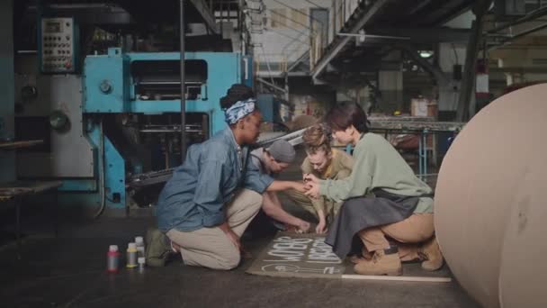 工业厂房女工多族裔小组坐在地板上 在准备工作场所罢工时张贴抗议标语和女权运动标语 — 图库视频影像