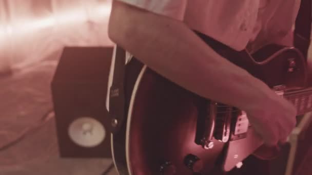 有才华的白人年轻摇滚音乐人在霓虹灯音乐工作室中表现出色地弹奏电吉他 — 图库视频影像