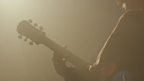 带电吉他的男性摇滚吉他手在霓虹灯舞台上表演音乐的背景慢镜头 — 图库视频影像
