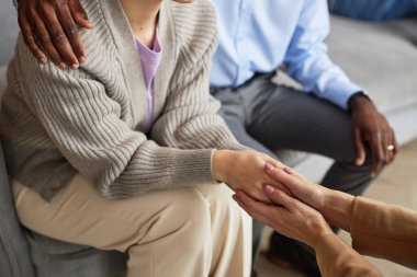 Zor bir konuşmadan sonra kadın müşterinin elini tutan psikolog.