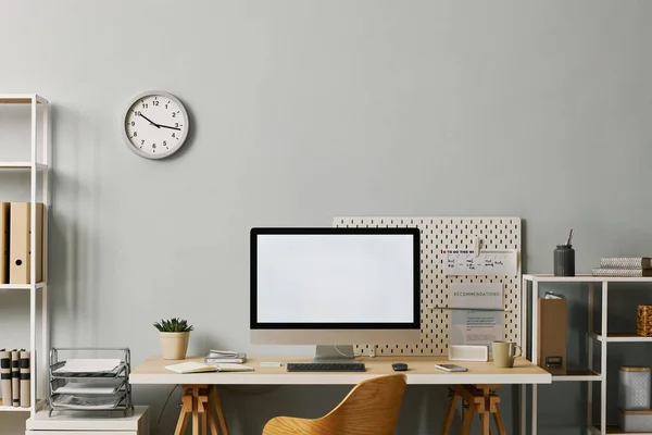 Background image of minima office setup with computer screen mockup on desk by pastel blue wall, copy space