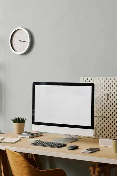 Vertical background image of minima office setup with computer screen mockup on desk by pastel blue wall