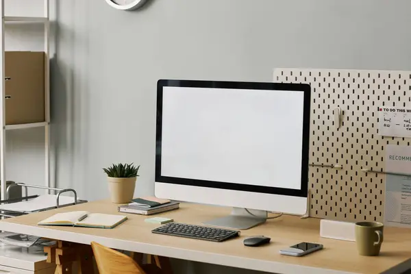 Background image of blank computer screen on minimal home office workplace set at angle, copy space