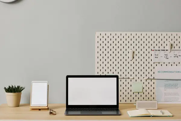 Minimal office setup with laptop screen mockup on desk, copy space