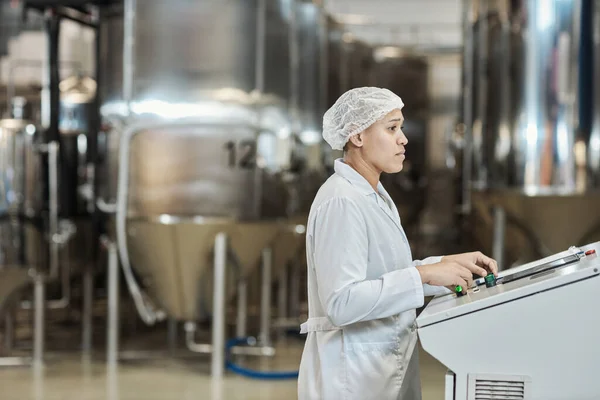 食品工場のラボコート操作装置を身に着けている女性労働者の側面図 コピースペース — ストック写真