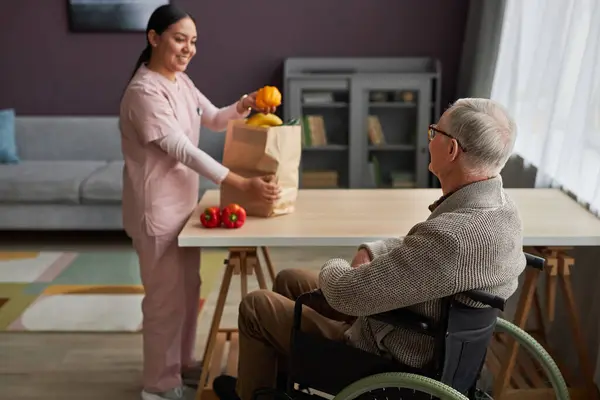 Young Social Worker Helping Senior Man Disability Buy Food She — Stock Photo, Image