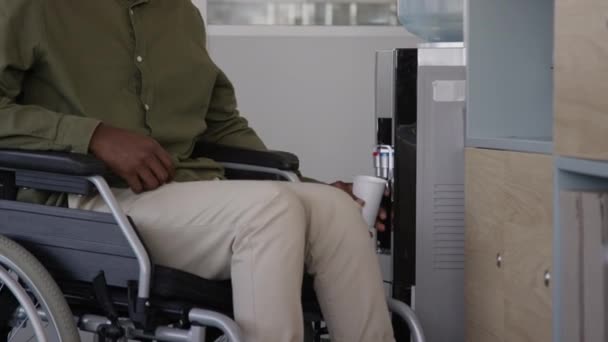 Młody Afroamerykanin Wózku Inwalidzkim Pijący Świeżą Wodę Plastikowego Kubka Siedzącego — Wideo stockowe