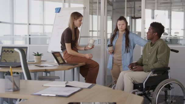 職場でのコーヒー休憩中に会話をする3人の多様な若い男性と女性のオフィスの同僚の中型ショット — ストック動画
