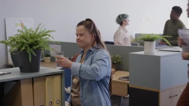 Średnie Ujęcie Młodej Białej Kobiety Zespołem Puchowym Podlewającej Zieloną Roślinę — Wideo stockowe