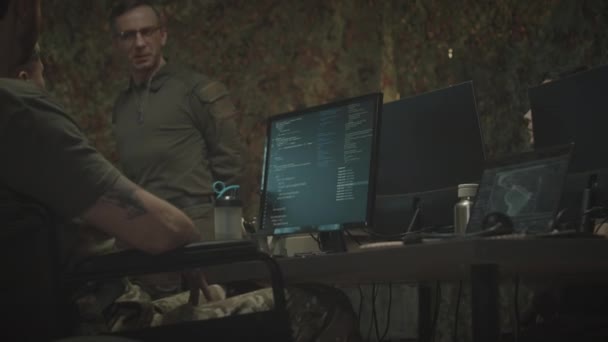 Tekerlekli Sandalyedeki Kamuflaj Üniformalı Askeri Çalışanın Ekranda Program Kodlarıyla Bilgisayar — Stok video