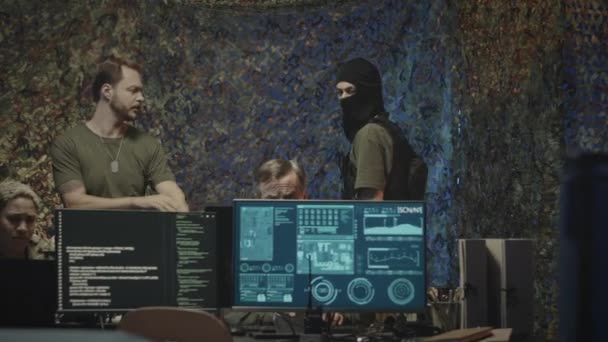 身着战术性面具 身穿防盗背心 夜间在黑暗的网络安全办公室工作的军事人员的中景照片 — 图库视频影像