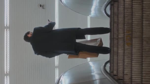 Metro Yürüyen Merdivenleri Çıkarken Elinde Kese Kağıdıyla Akıllı Telefon Kullanan — Stok video