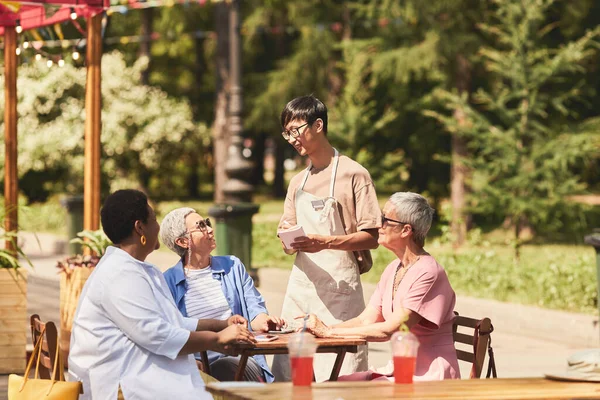 Portrait Active Senior Women Sitting Table Outdoor Cafe Talking Waiter — Stock Photo, Image
