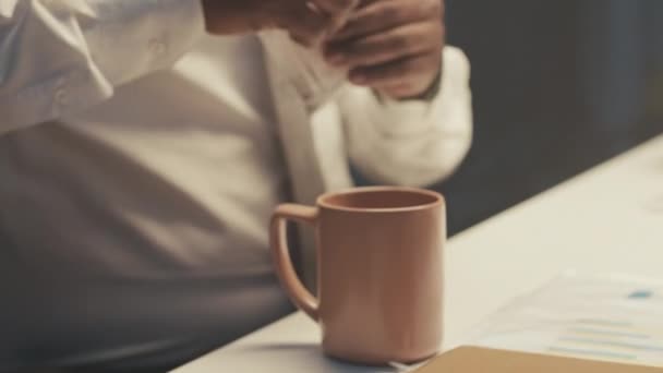 穿着白衬衫打领带 让自己在黑办公室加班时把咖啡滴在杯子里 让人认不出来的商人拍了照 — 图库视频影像