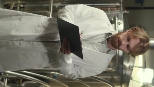 실험실 코트에있는 코카서스 양조장 감독자의 초상화 보드에 메모를 카메라를보고 공장을 — 비디오