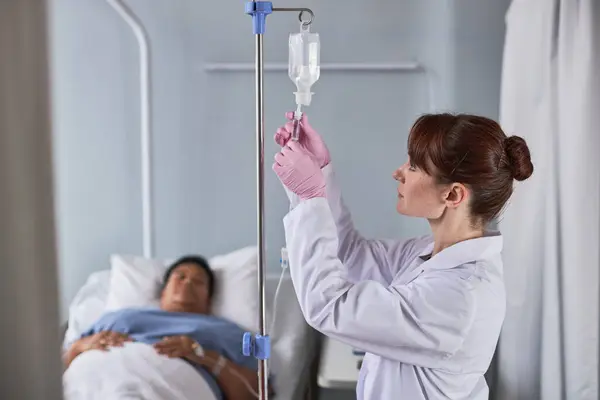 Side View Portrait Nurse Adjusting Fluid Setup Hospital While Caring — Stock Photo, Image
