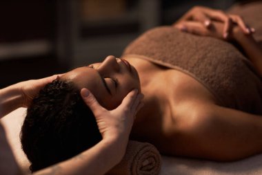 Kozmetik uzmanı, genç bir kadının yüzüne nazikçe masaj yapıyor.