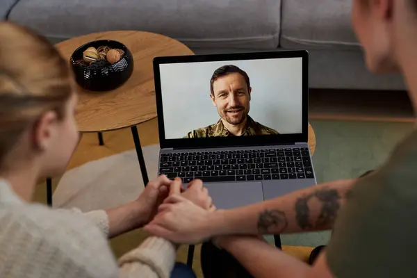Portrait of smiling military man on laptop screen talking to family by video chat