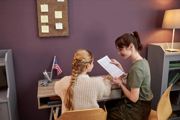 Genç bir annenin orduda çalışıp kızına ev ödevlerinde yardım etmesi.