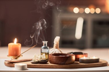Yanan tütsü çubuğu, mumlar ve spa salonundaki masada bir kase tuz fırçası.